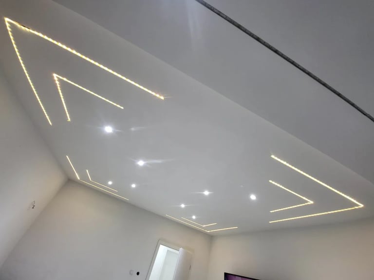 Modern ceiling with geometric neon-style lighting strips and recessed spotlights in a minimalist interior space